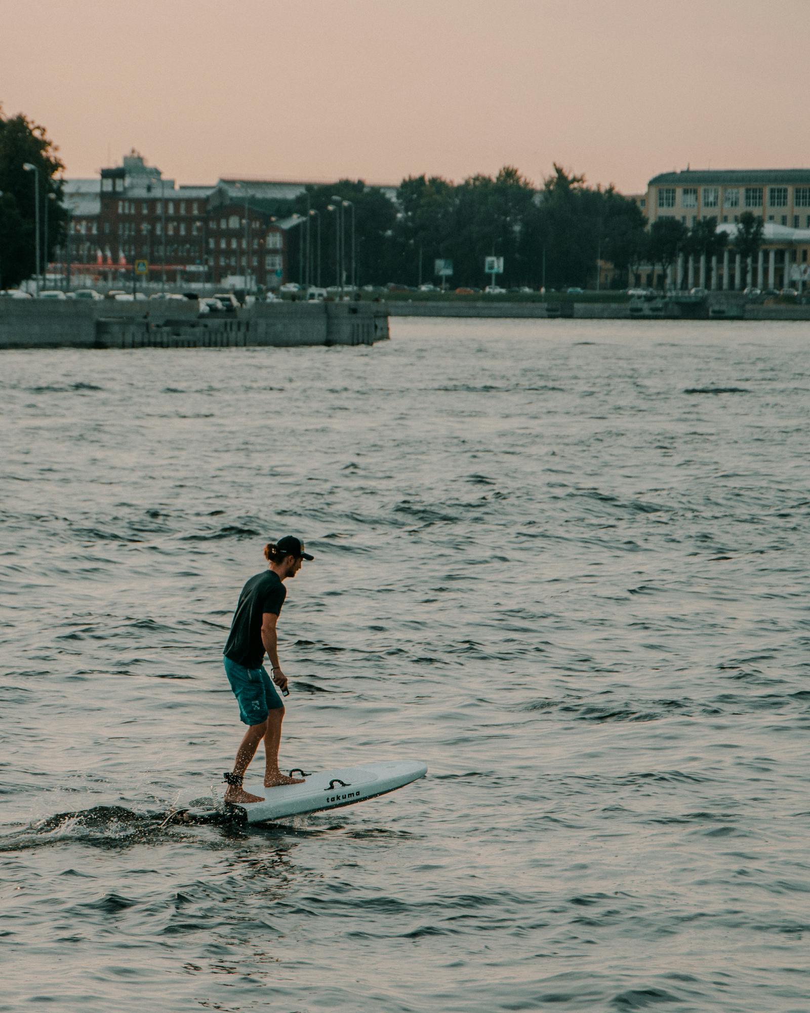 Man riding a hydrofoil surfboard above the ocean